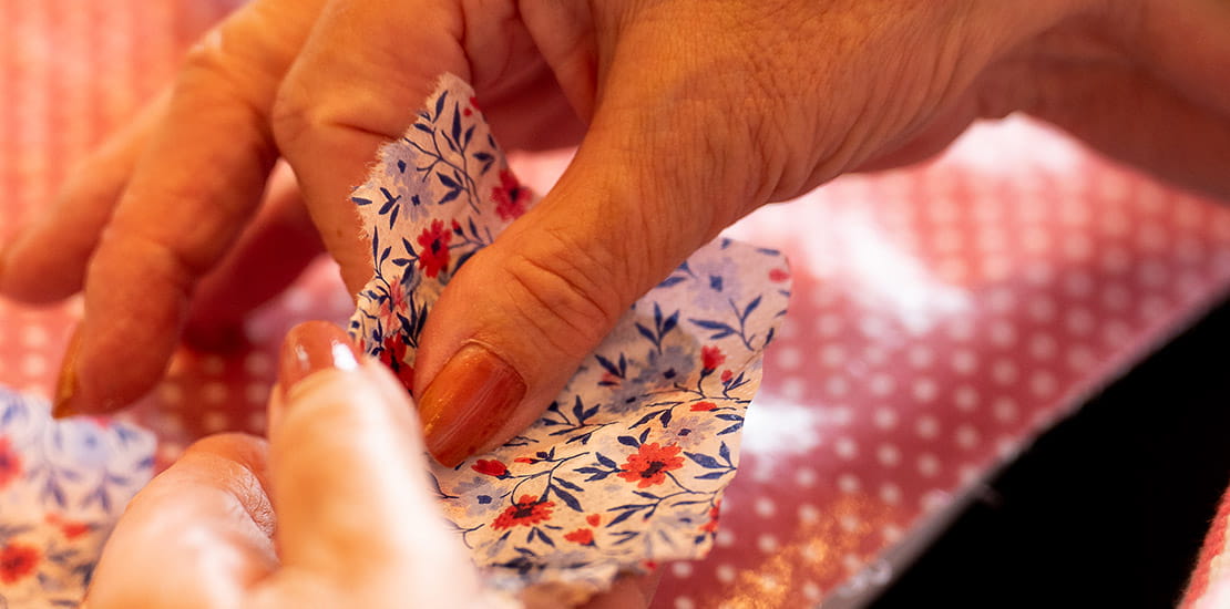 An oyster shell being decorated with flowery fabric during a workshop with the Supercrafters